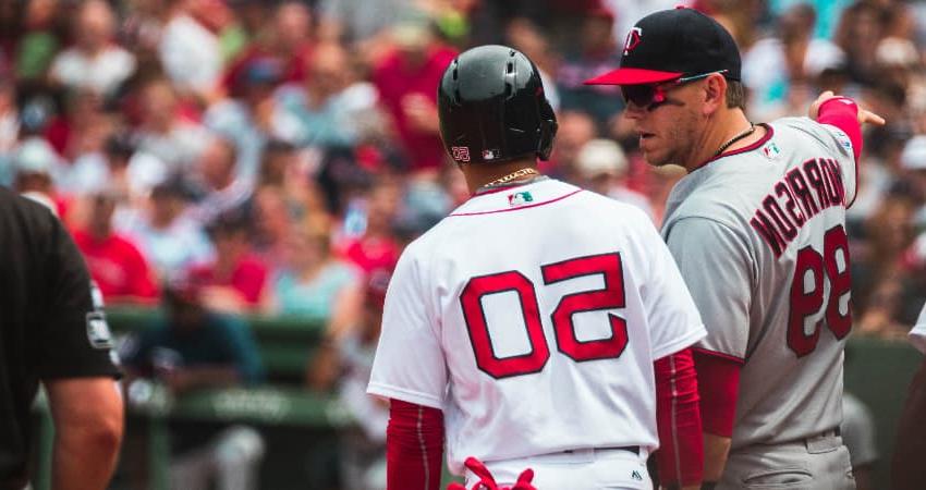 Two baseball player talk on the field, fans filling the seats of 芬威球场 in Boston